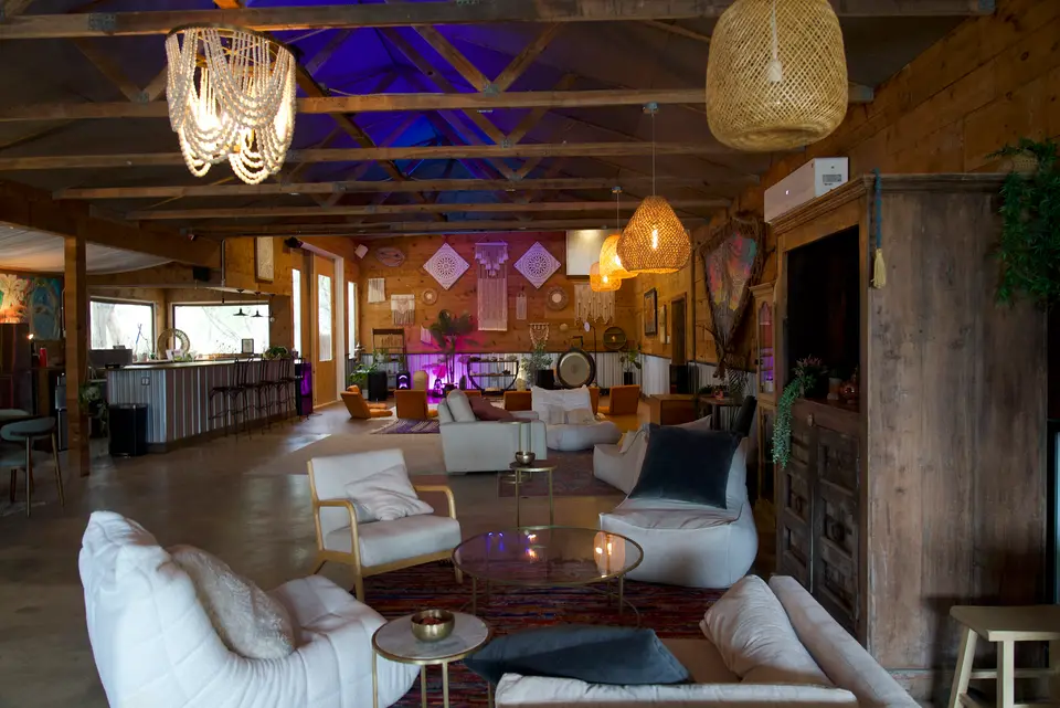 Inside the open-air temple: a timber-framed pavilion with draped fabric and low seating.