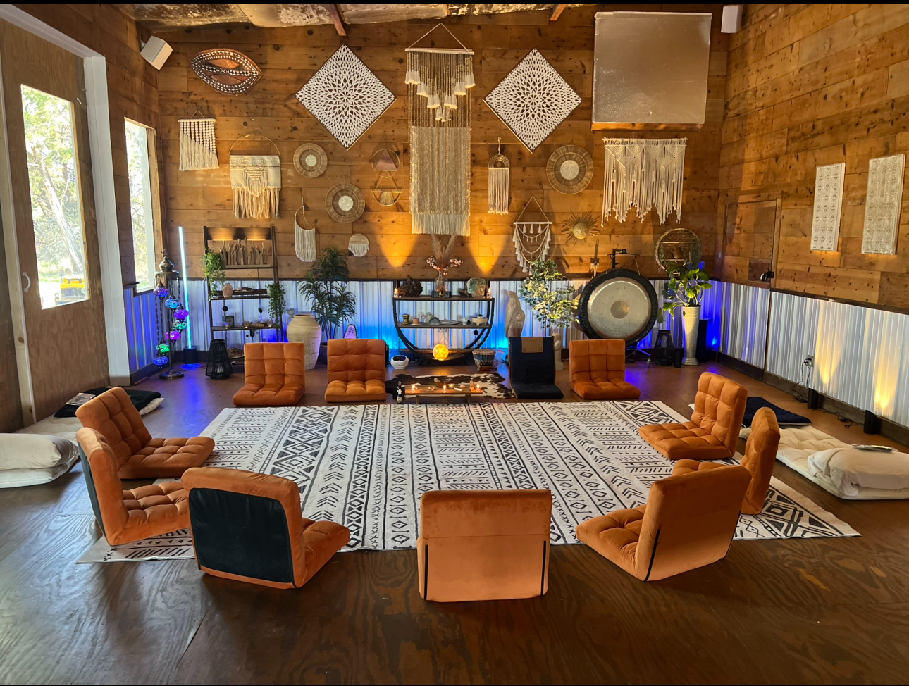 The Temple ceremony space with orange floor chairs, macrame, and gong